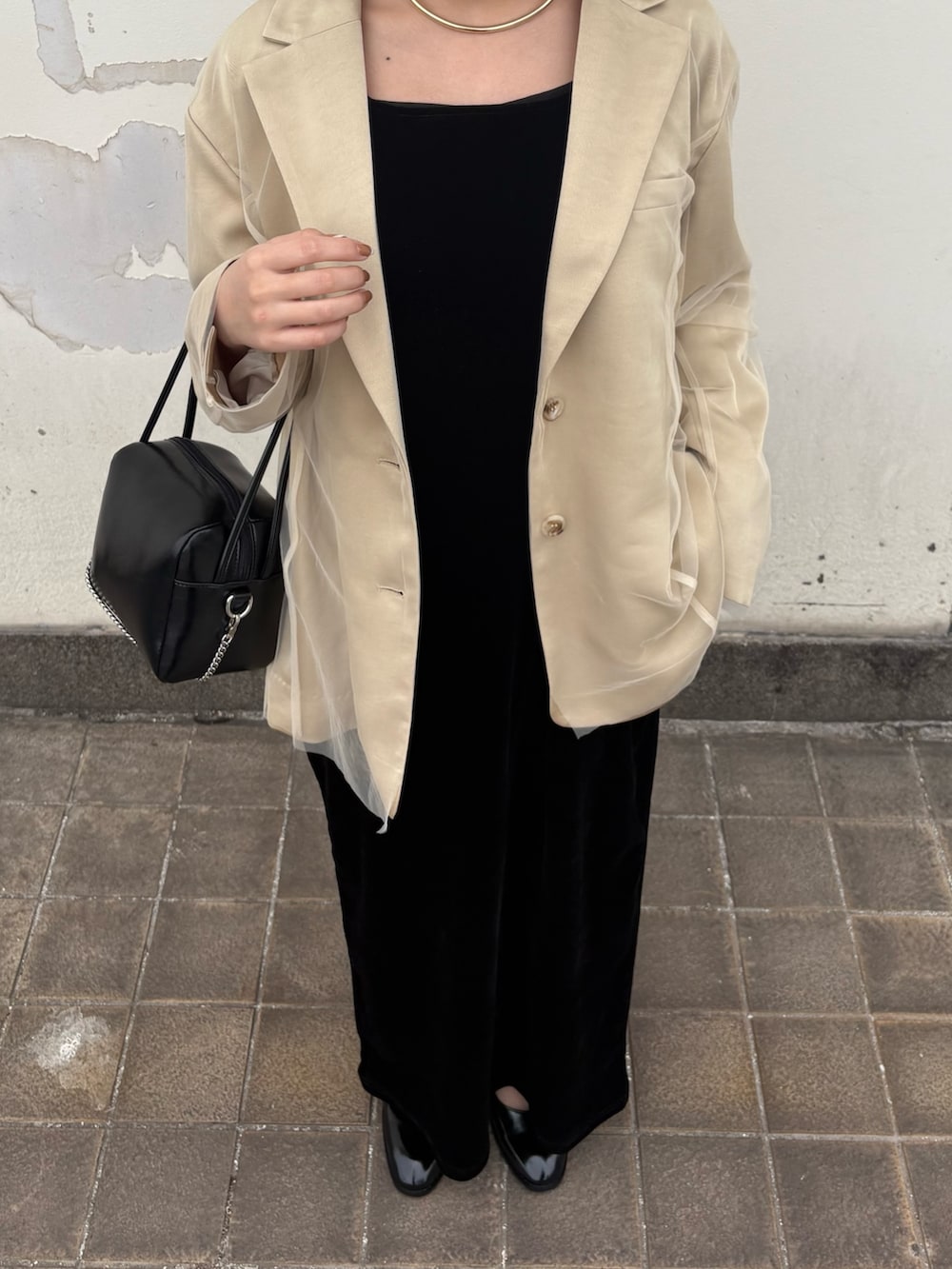 ベージュ系のその他アウター、ブラック系のワンピース、ブラック系のローファーを着用したレディースの春コーディネートの2枚目の写真