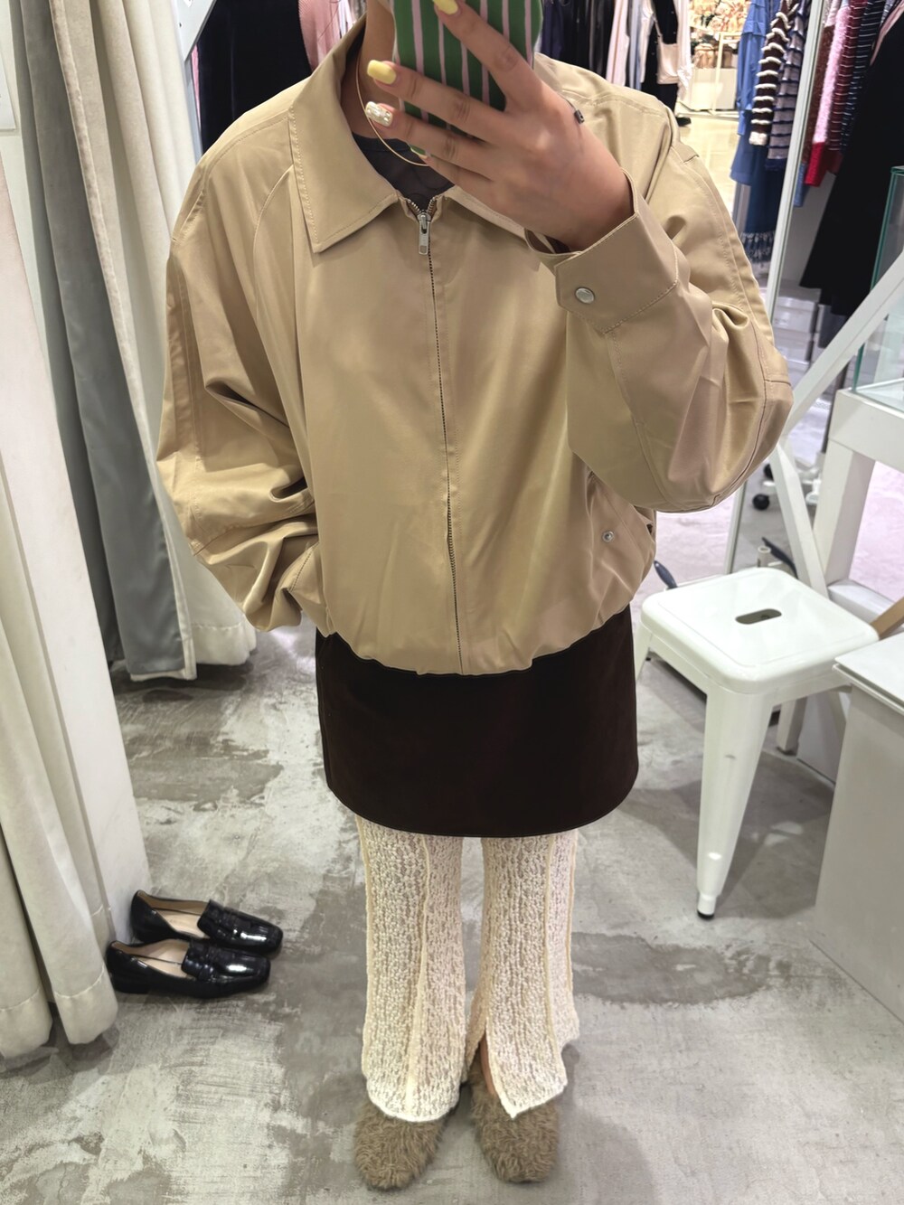 ベージュ系のブルゾン、ブラウン系のスカート、ホワイト系のその他パンツを着用したレディースの秋コーディネートの4枚目の写真