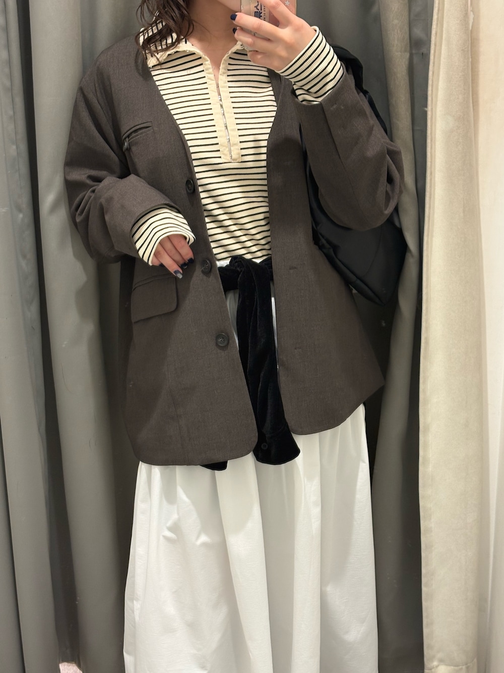 ブラウン系のノーカラージャケット、ホワイト系のスカート、ブラック系のブーツを着用したレディースの冬コーディネートの6枚目の写真