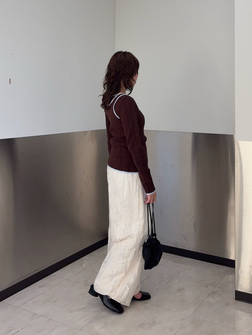 ブラウン系のニット/セーター、ホワイト系のその他パンツ、ブラック系のパンプスを着用したレディースの冬コーディネートの2枚目の写真