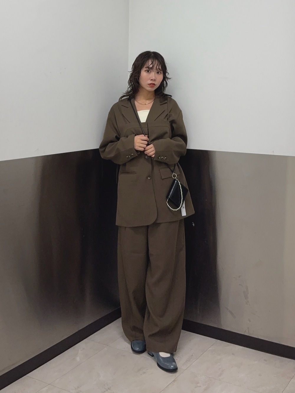 ブラウン系のその他アウター、ブラウン系のその他パンツ、ホワイト系のタンクトップを着用したレディースの秋コーディネートの4枚目の写真