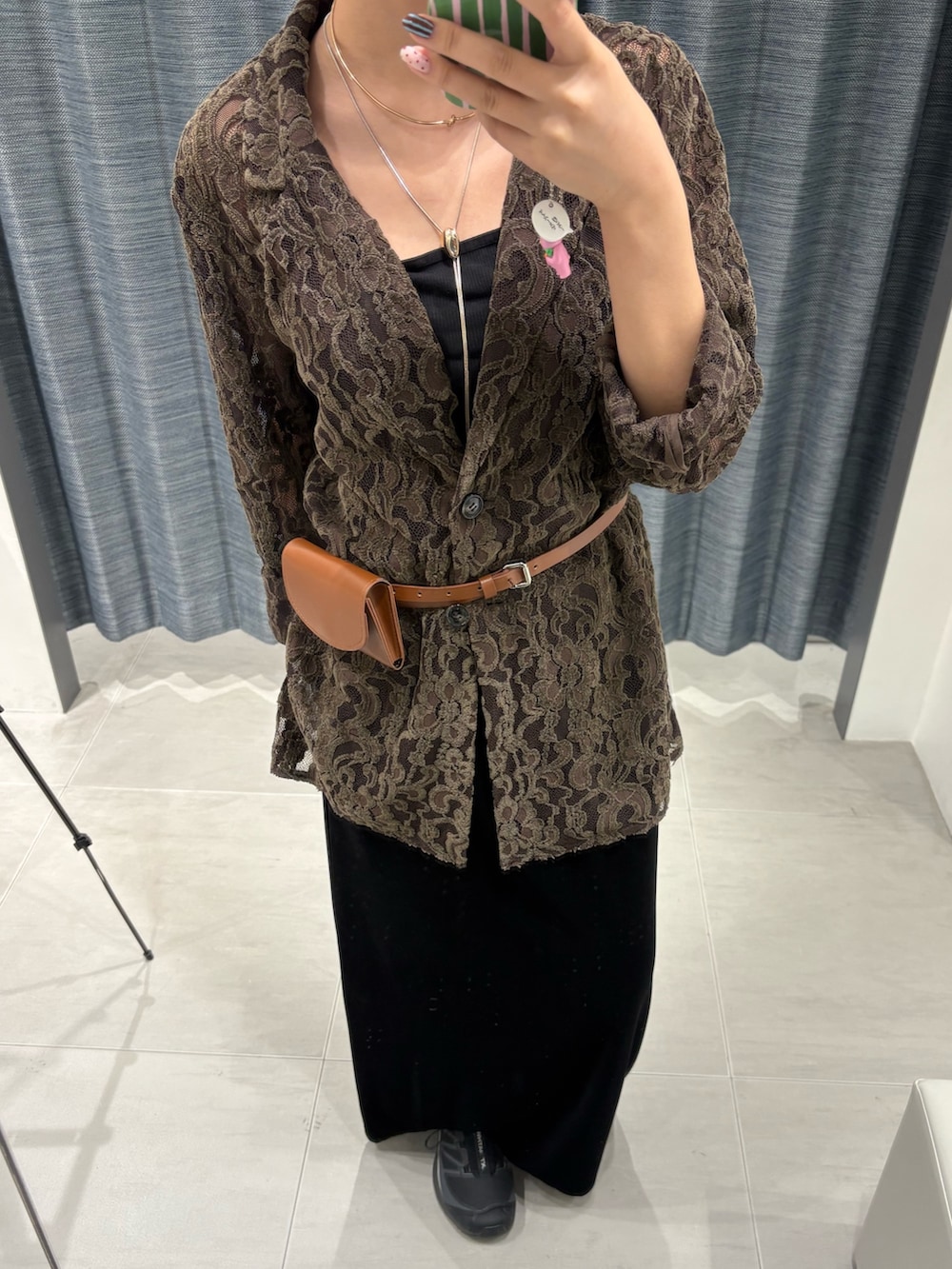 ブラウン系のその他アウター、ブラック系のスカート、ブラック系のスニーカーを着用したレディースの秋コーディネートの4枚目の写真