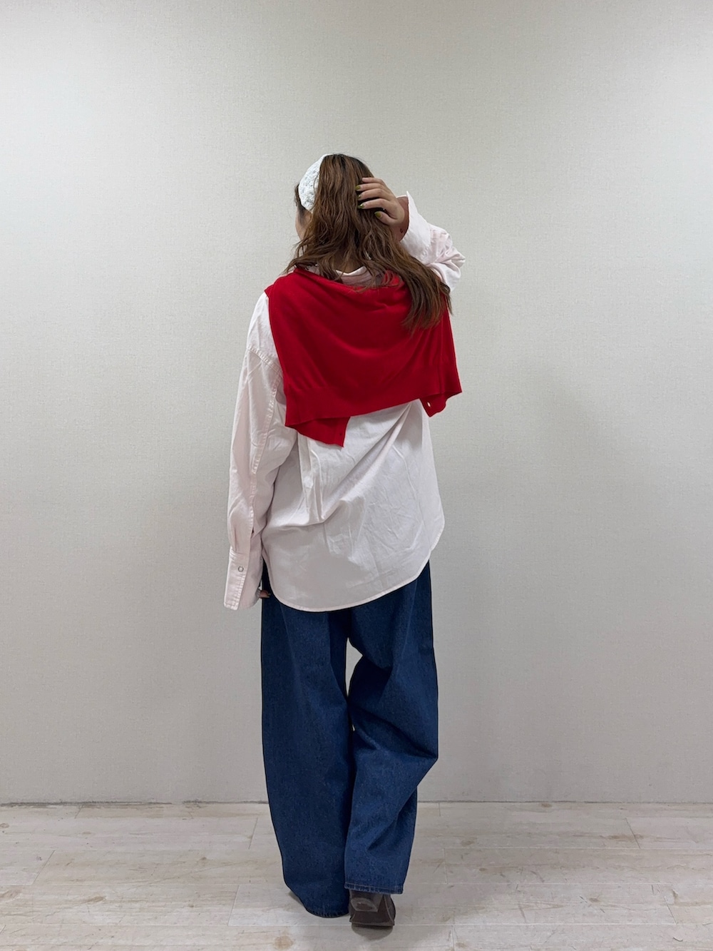 レッド系のカーディガン/ボレロ、ピンク系のシャツ/ブラウス、ブルー系のデニムパンツを着用したレディースの秋コーディネートの3枚目の写真