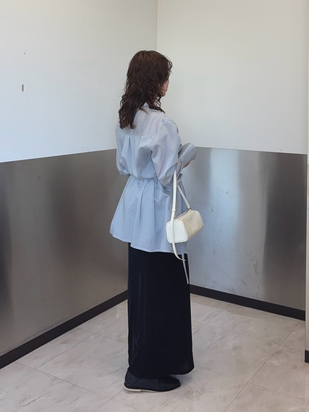 ブルー系のシャツ/ブラウス、ブラック系のスカート、ブラック系のパンプスを着用したレディースの冬コーディネートの2枚目の写真