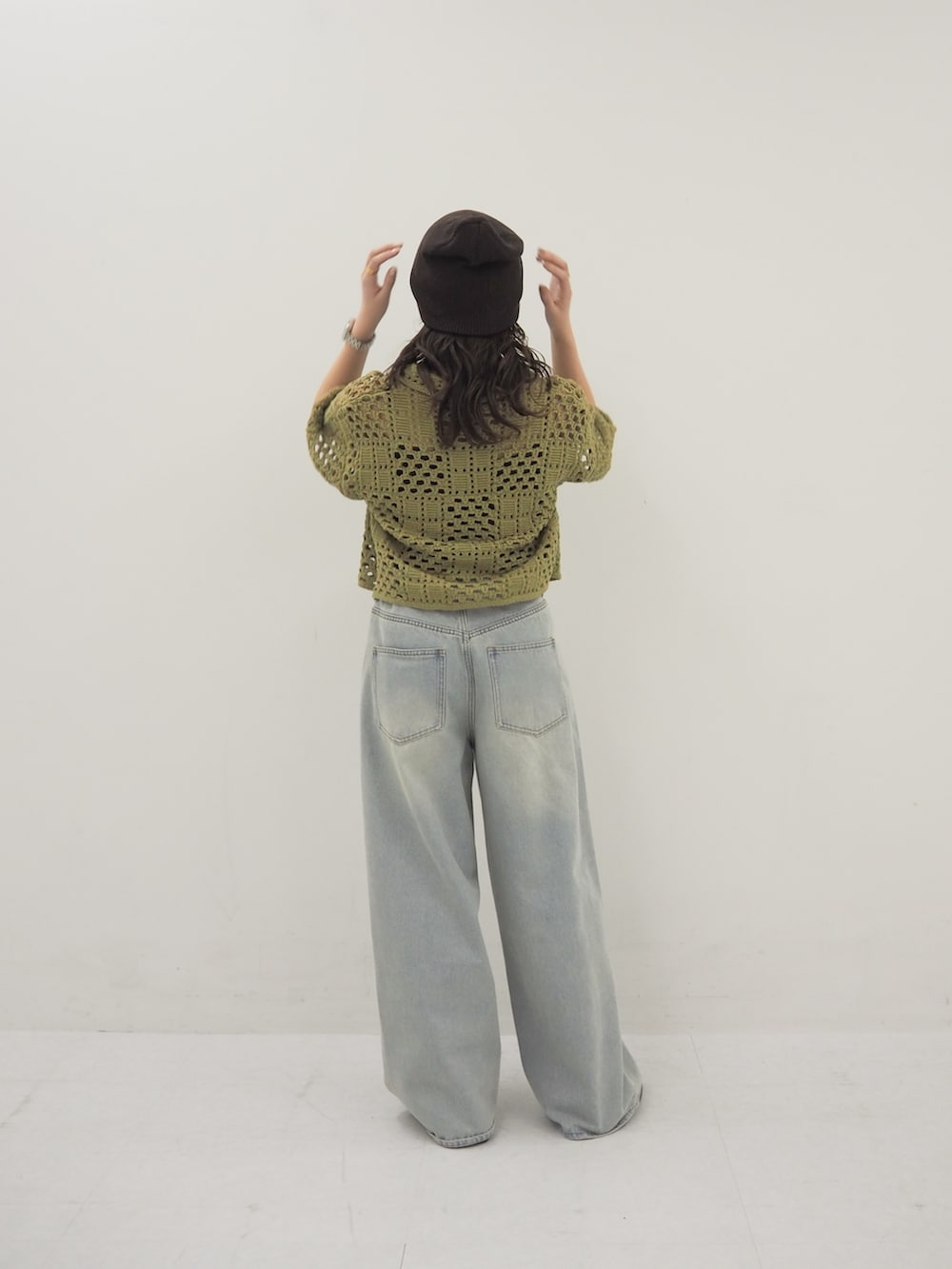 グリーン系のニット/セーター、ブラック系のその他シューズ、グレー系のニットキャップ/ビーニーを着用したレディースの春コーディネートの3枚目の写真