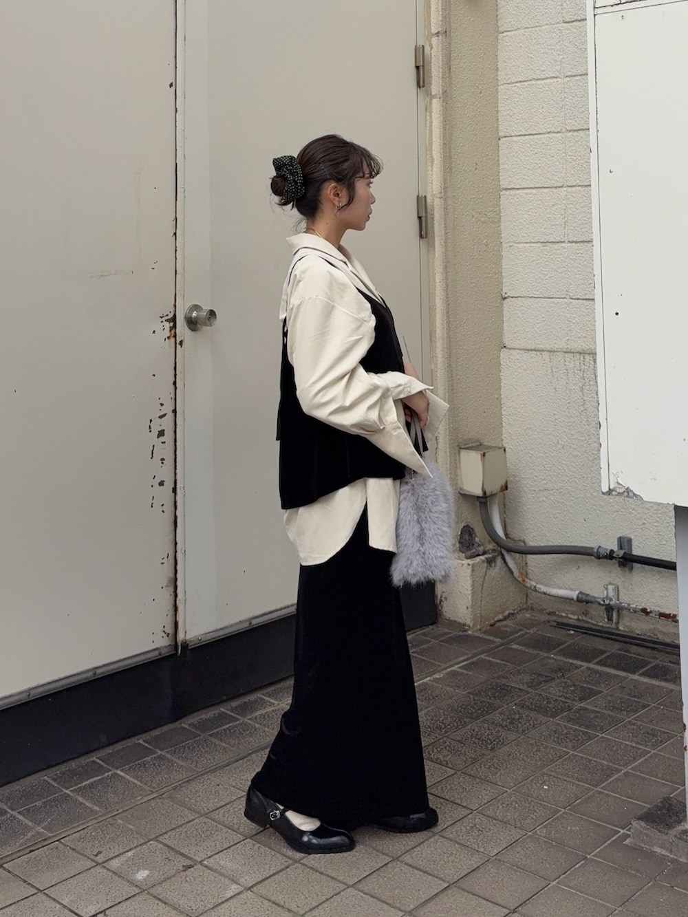 ブラック系のキャミソール、ブラック系のスカート、ホワイト系のシャツ/ブラウスを着用したレディースの秋コーディネートの3枚目の写真