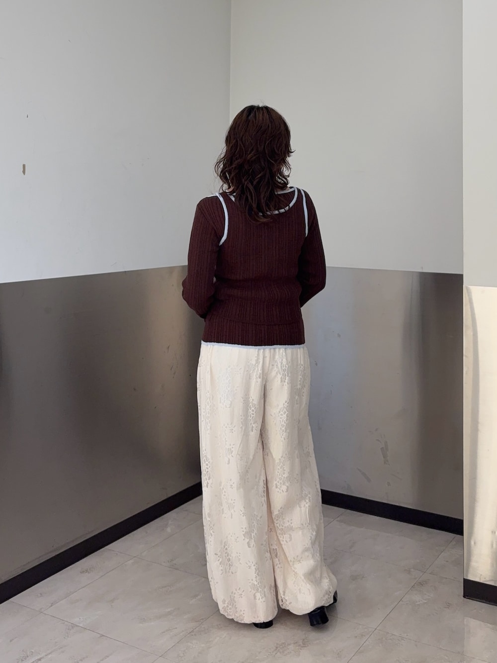 ブラウン系のニット/セーター、ホワイト系のその他パンツ、ブラック系のパンプスを着用したレディースの冬コーディネートの3枚目の写真