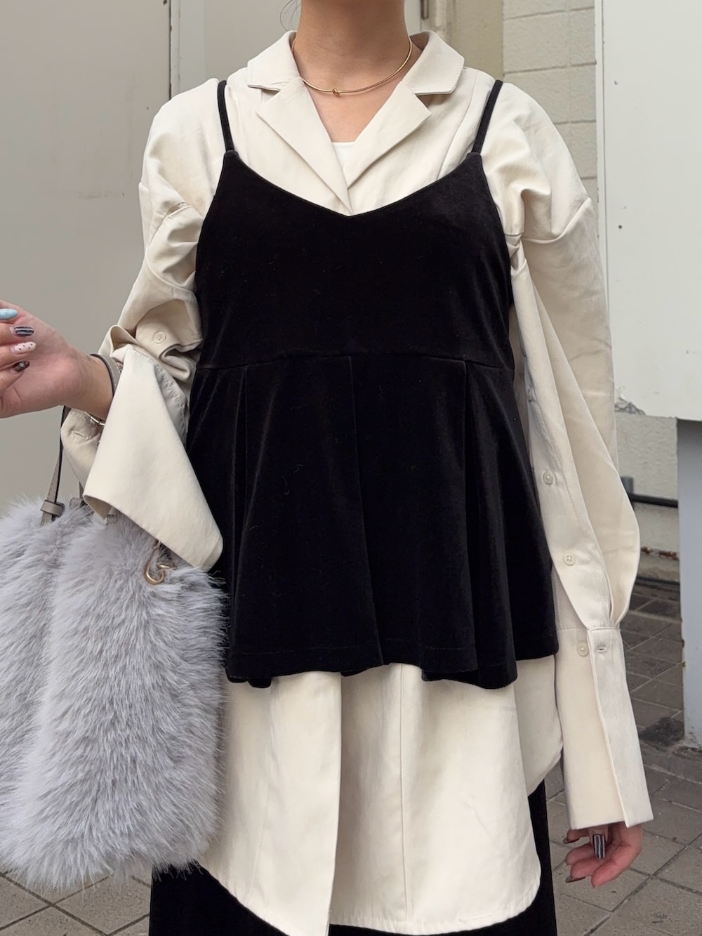 ブラック系のキャミソール、ブラック系のスカート、ホワイト系のシャツ/ブラウスを着用したレディースの秋コーディネートの5枚目の写真