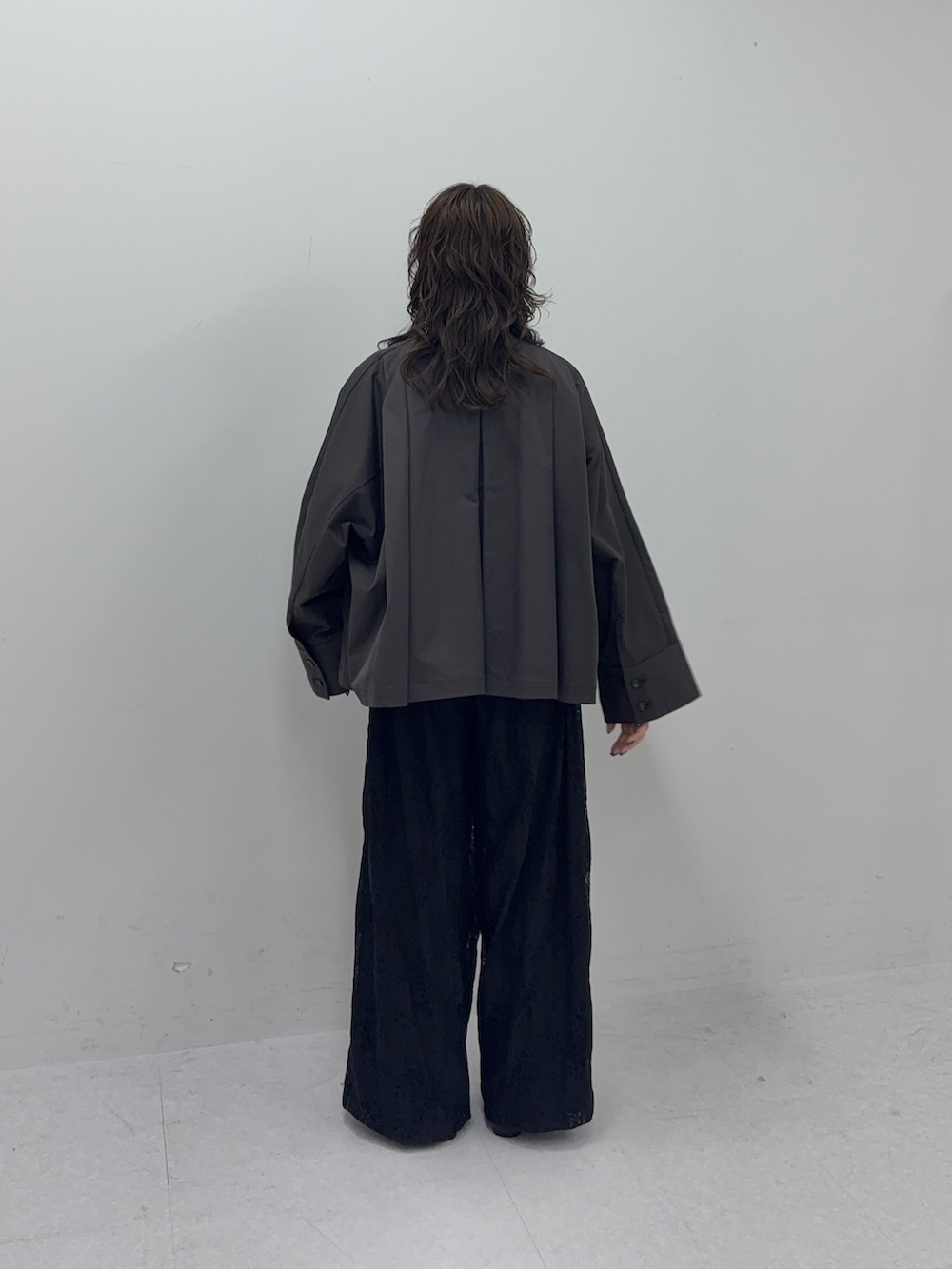 グレー系のステンカラーコート、ブラック系のその他パンツ、ブラック系のその他シューズを着用したレディースの冬コーディネートの3枚目の写真