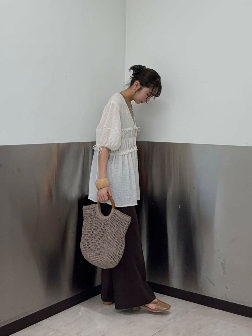 ベージュ系のタンクトップ、グレー系のトートバッグ、イエロー系のパンプスを着用したレディースの夏コーディネートの2枚目の写真