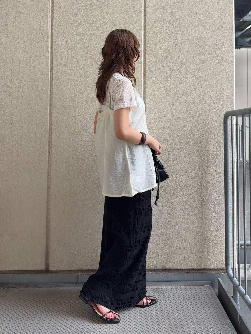 ホワイト系のTシャツ/カットソー、ブラック系のスカート、ブラック系のハンドバッグを着用したレディースの夏コーディネートの2枚目の写真