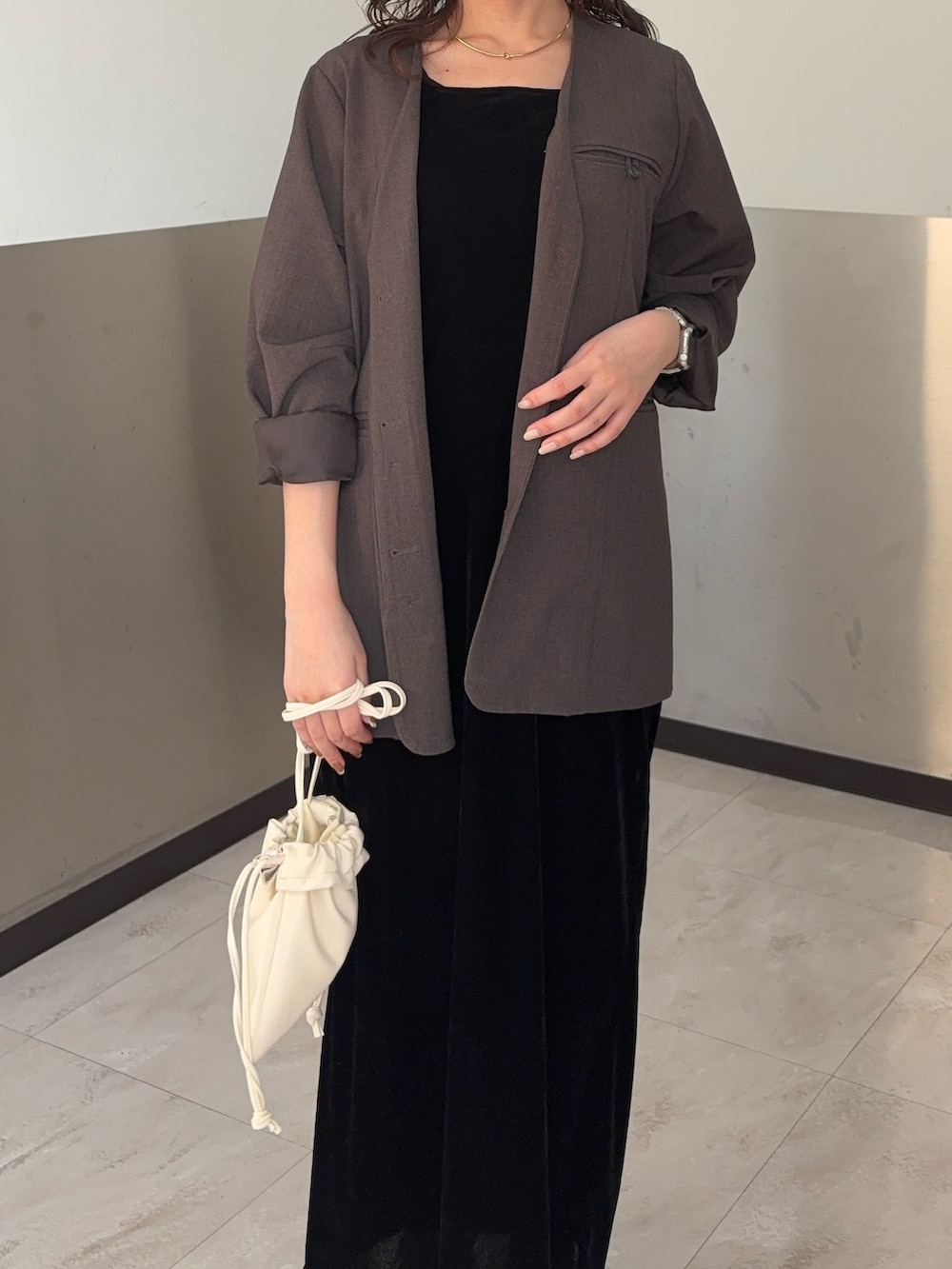 ブラウン系のノーカラージャケット、ブラック系のワンピース、ブラック系のローファーを着用したレディースの春コーディネートの4枚目の写真