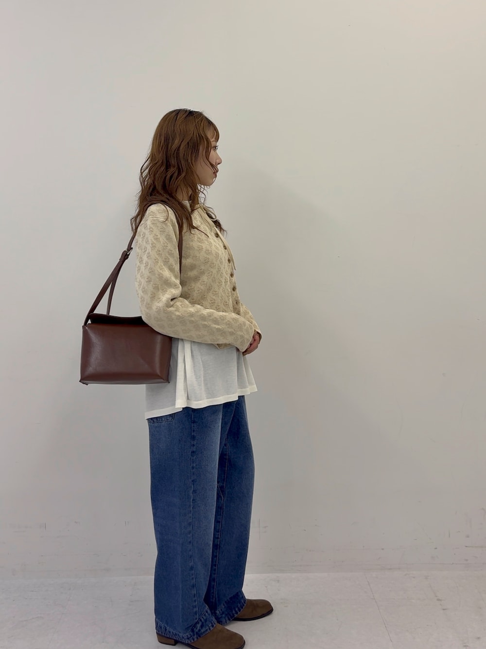 ベージュ系のカーディガン/ボレロ、ブルー系のデニムパンツ、ブラウン系のその他シューズを着用したレディースの秋コーディネートの2枚目の写真