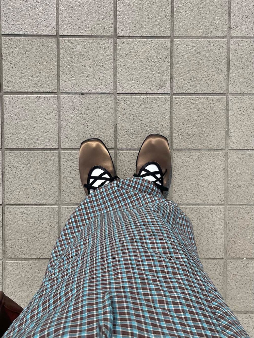 ブラウン系のボストンバッグ、グリーン系のスニーカー、ブルー系のワンピースを着用したレディースの春コーディネートの6枚目の写真