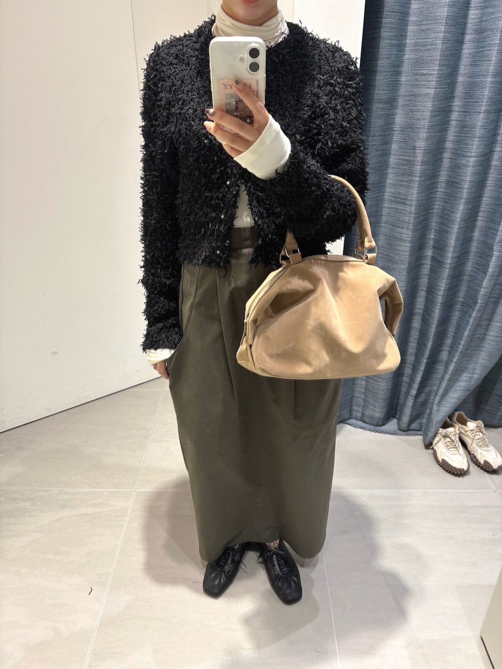 ホワイト系のTシャツ/カットソー、ブラック系のニット/セーター、ベージュ系のボストンバッグを着用したレディースの冬コーディネートの4枚目の写真