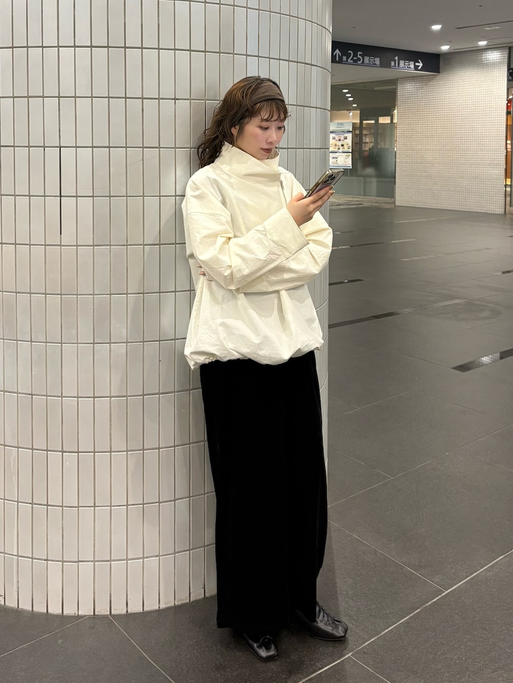 ブラック系のワンピース、ブラック系のその他シューズ、ホワイト系のその他アウターを着用したレディースの春コーディネートの2枚目の写真