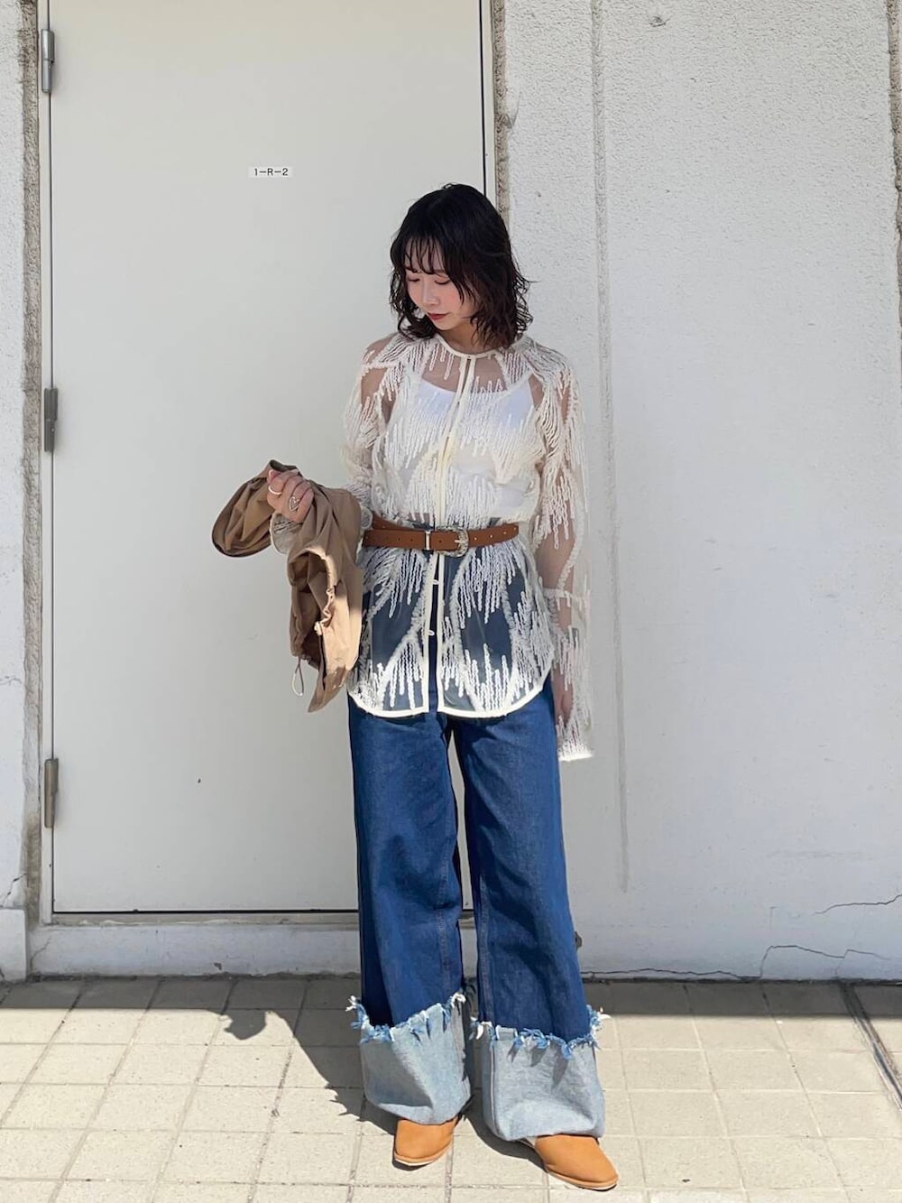 イエロー系のベスト、ブルー系のデニムパンツ、ホワイト系のシャツ/ブラウスを着用したレディースの春コーディネートの5枚目の写真