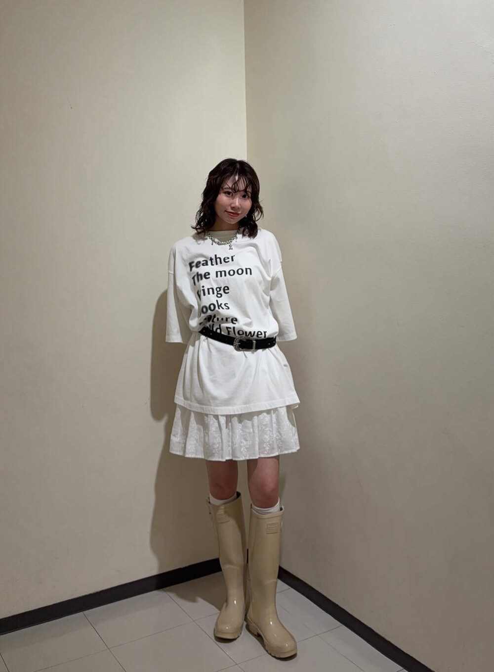 ホワイト系のスカート、ホワイト系のTシャツ/カットソー、ブラック系のベルトを着用したレディースの春コーディネートの2枚目の写真