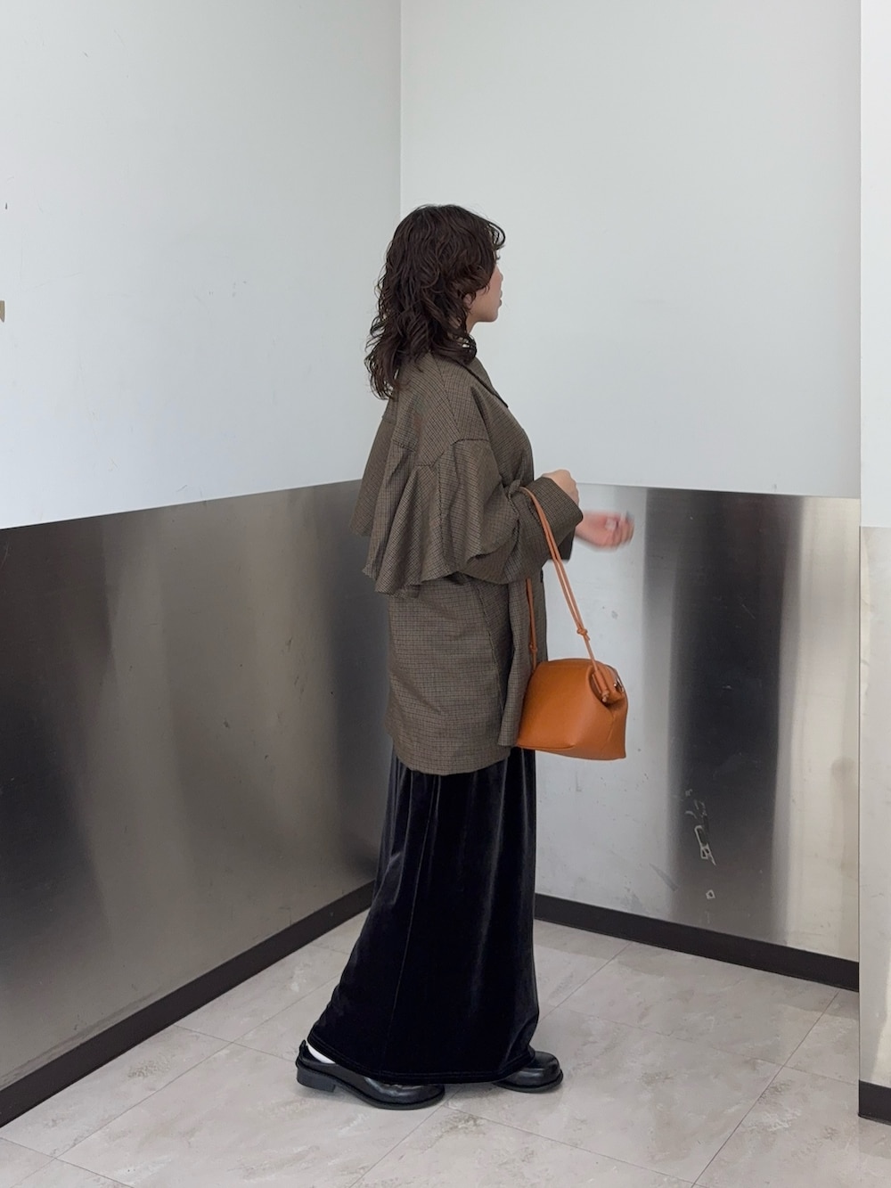 ブラウン系のその他アウター、グレー系のスカート、ブラック系のその他シューズを着用したレディースの秋コーディネートの2枚目の写真