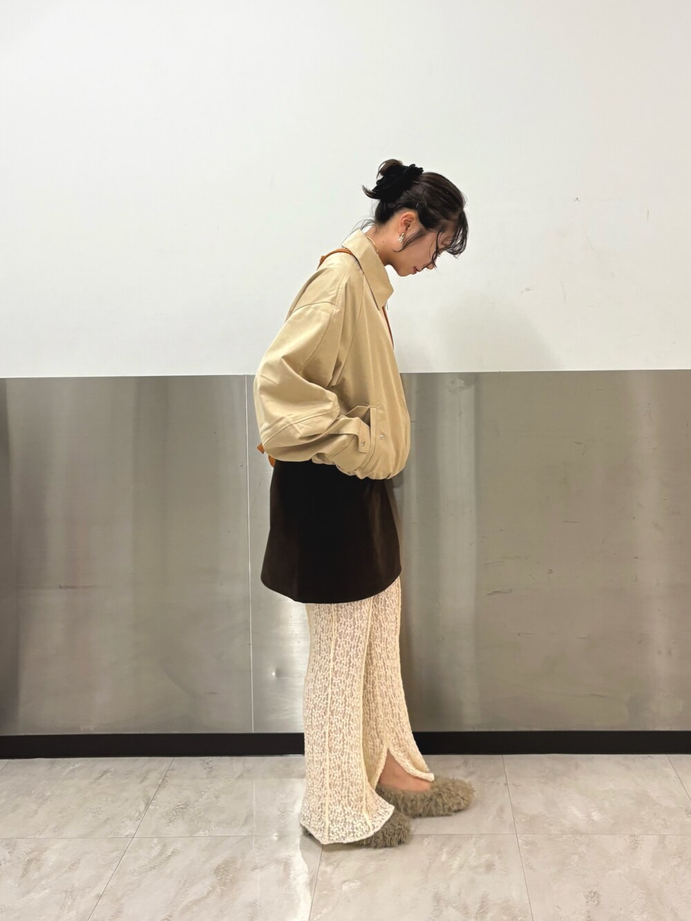 ベージュ系のブルゾン、ブラウン系のスカート、ホワイト系のその他パンツを着用したレディースの秋コーディネートの2枚目の写真