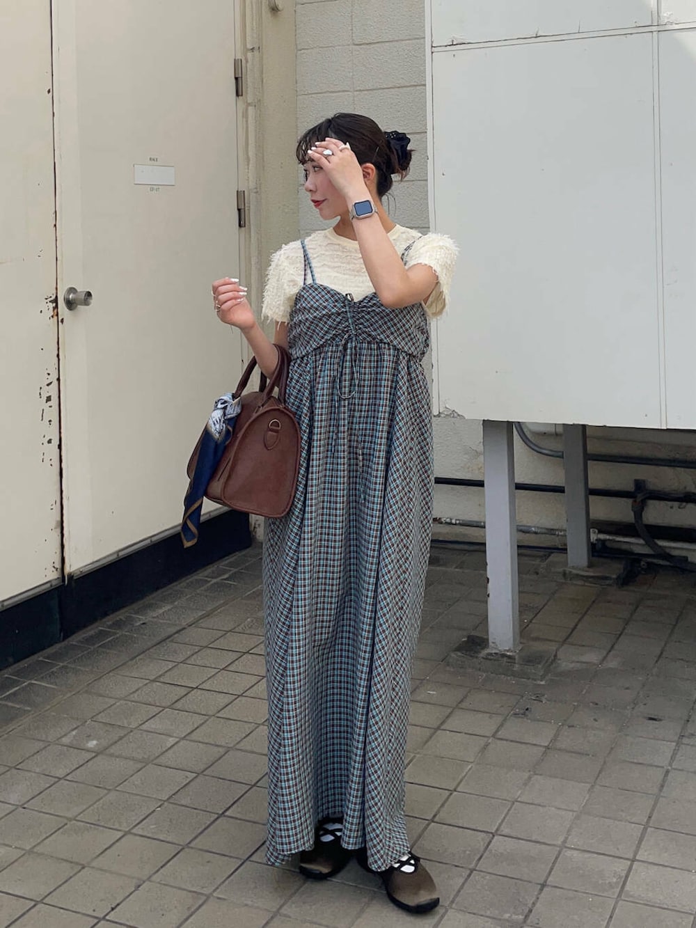 ブラウン系のボストンバッグ、グリーン系のスニーカー、ブルー系のワンピースを着用したレディースの春コーディネートの4枚目の写真