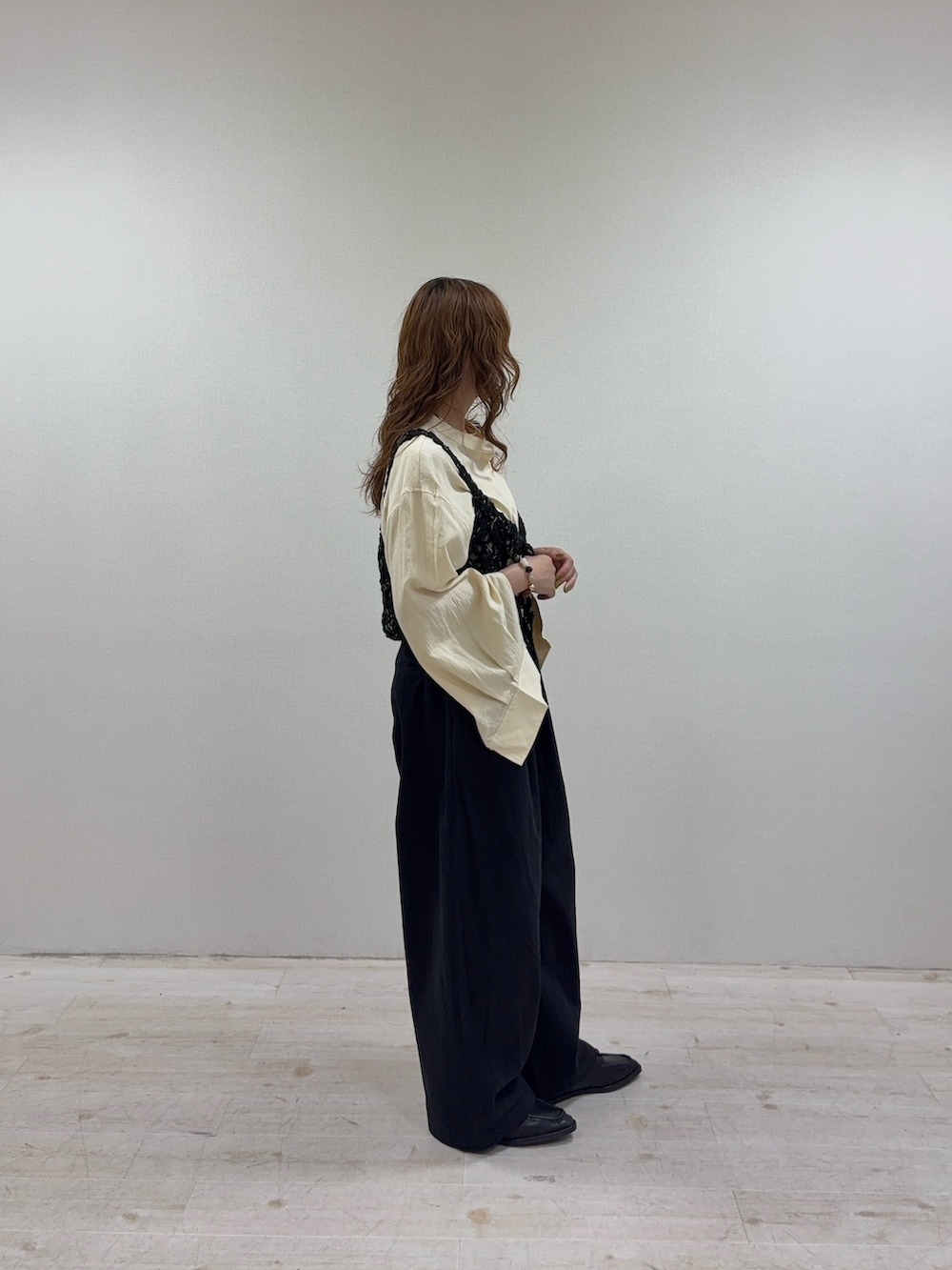 イエロー系のシャツ/ブラウス、ブラック系のニット/セーター、ブラック系のその他パンツを着用したレディースの秋コーディネートの2枚目の写真