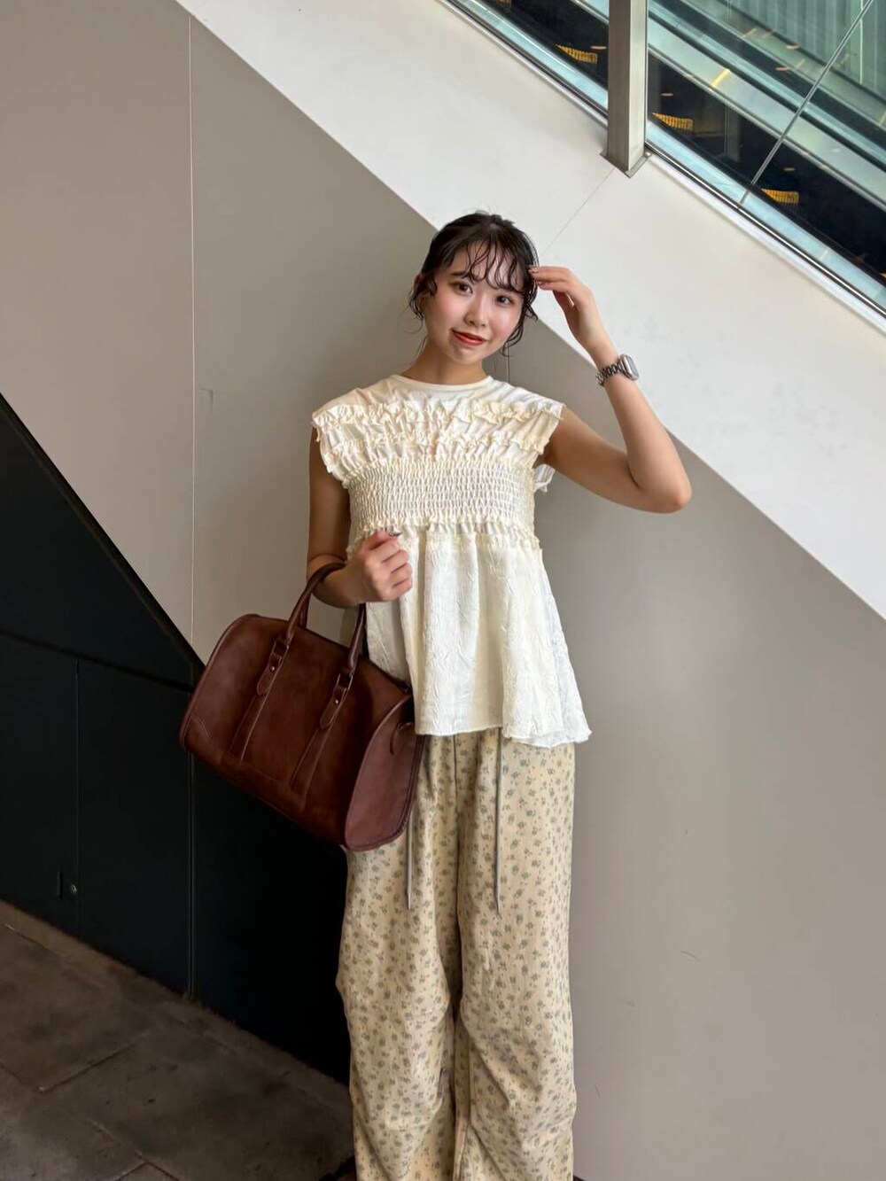 ブラウン系のボストンバッグ、ベージュ系のその他パンツ、イエロー系のサンダルを着用したレディースの夏コーディネートの3枚目の写真