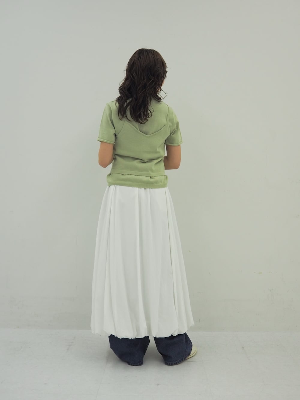 ベージュ系のカーディガン/ボレロ、ブルー系のデニムパンツ、ホワイト系のパンプスを着用したレディースの春コーディネートの3枚目の写真