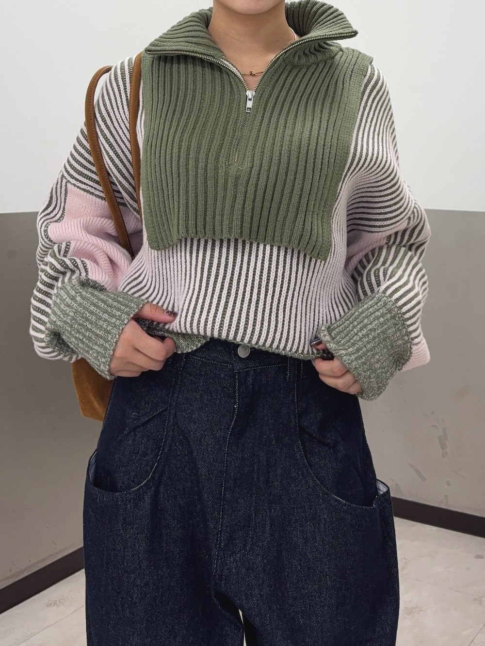 グリーン系のニット/セーター、ブルー系のデニムパンツ、ブラウン系のその他シューズを着用したレディースの秋コーディネートの5枚目の写真