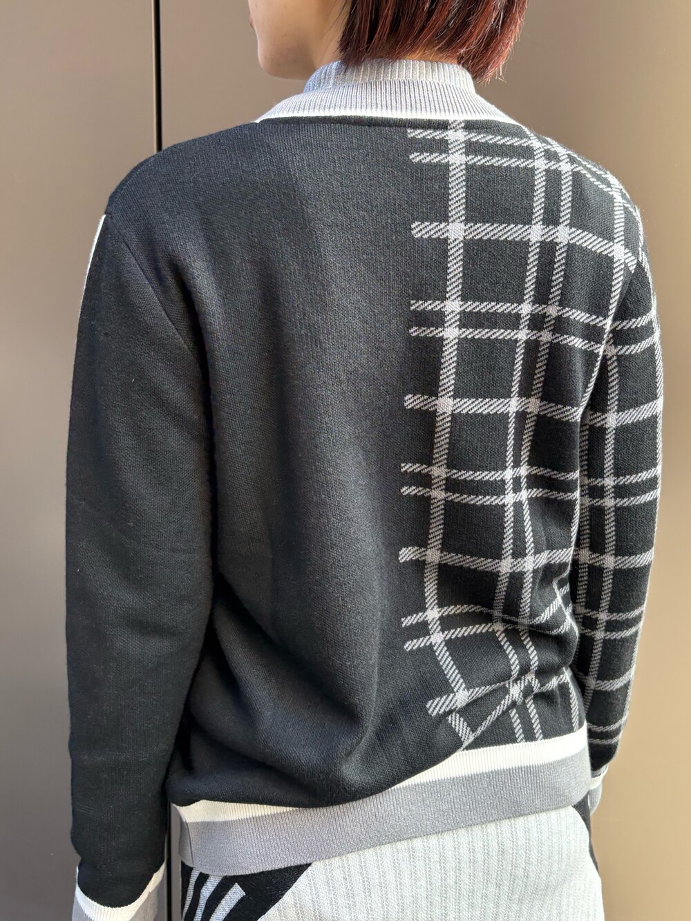 ブラック系のカーディガン/ボレロ、ホワイト系のニット/セーター、ホワイト系のスカートを着用したレディースの秋コーディネートの3枚目の写真