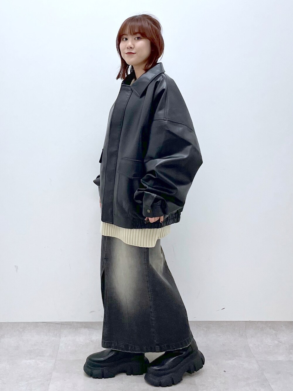 ブラック系のブーツ、ブラック系のスカート、ブラック系のブルゾンを着用したレディースの秋コーディネートの3枚目の写真