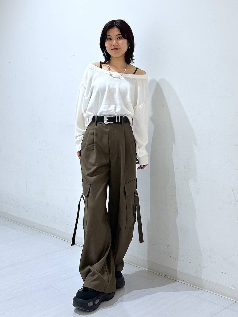 ホワイト系のTシャツ/カットソー、ブラウン系のスラックス、ブラック系のベルトを着用したレディースの秋コーディネートの3枚目の写真