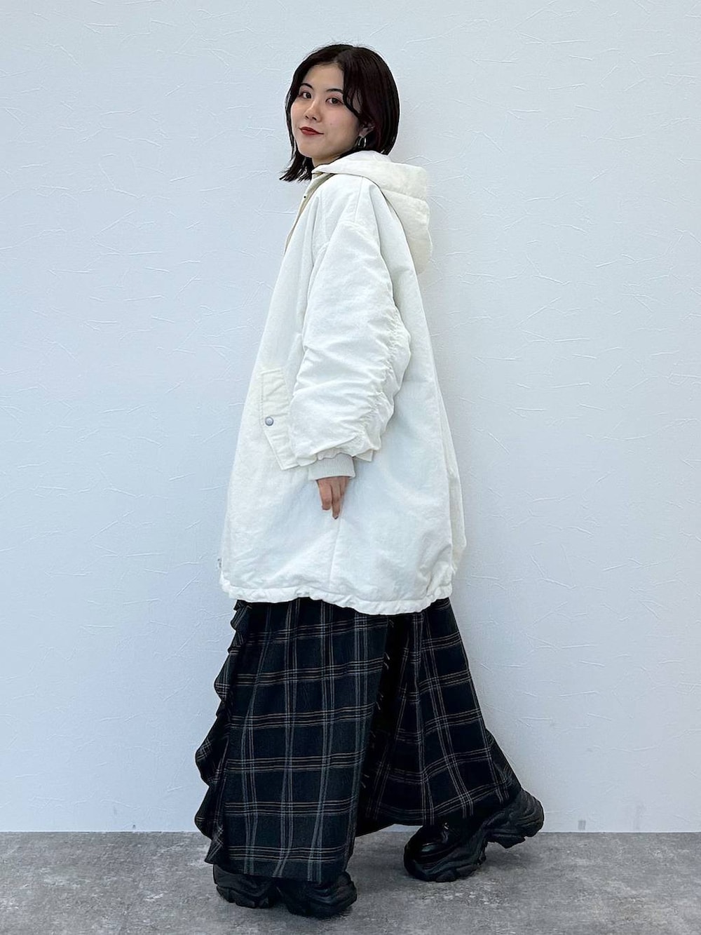 ブラック系のスニーカー、ホワイト系のブルゾン、ブルー系のニット/セーターを着用したレディースの秋コーディネートの5枚目の写真