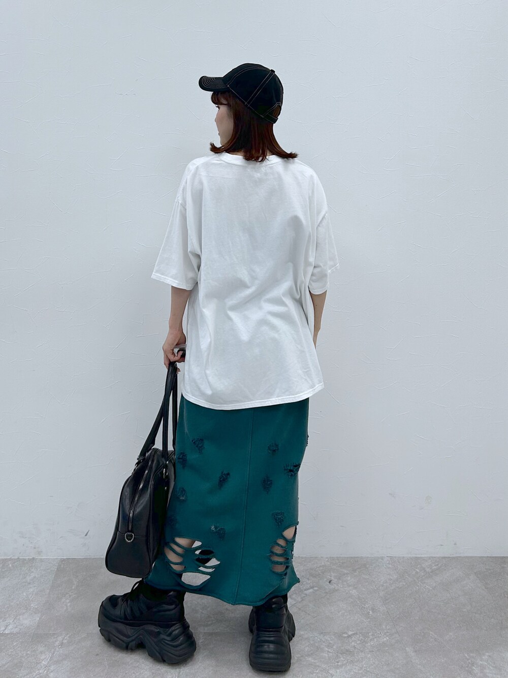 ブラック系のボストンバッグ、ブラック系のスニーカー、ホワイト系のTシャツ/カットソーを着用したレディースの春コーディネートの4枚目の写真