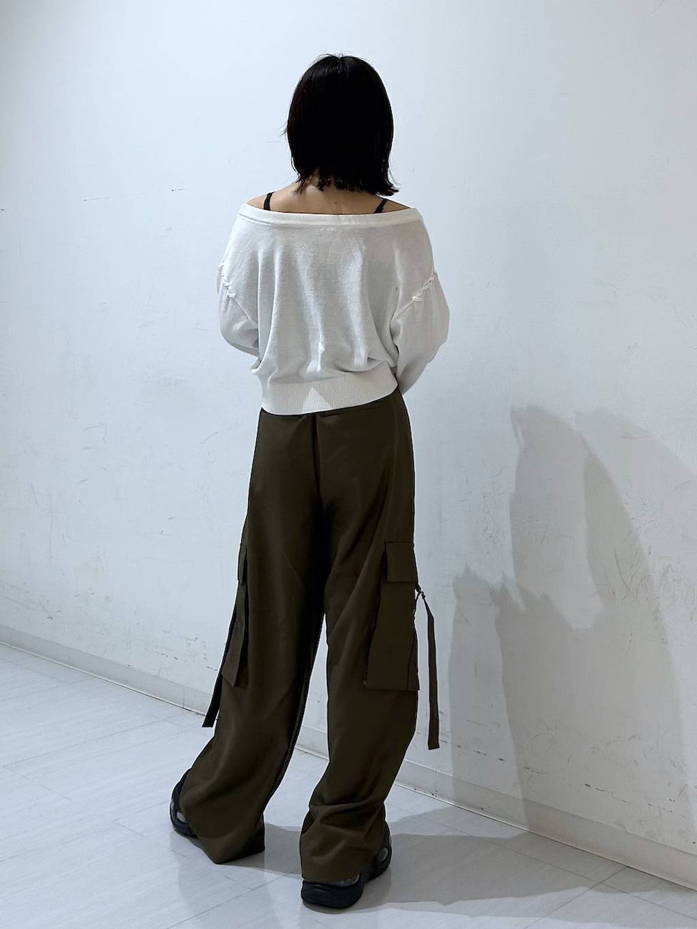 ホワイト系のTシャツ/カットソー、ブラウン系のスラックス、ブラック系のベルトを着用したレディースの秋コーディネートの6枚目の写真