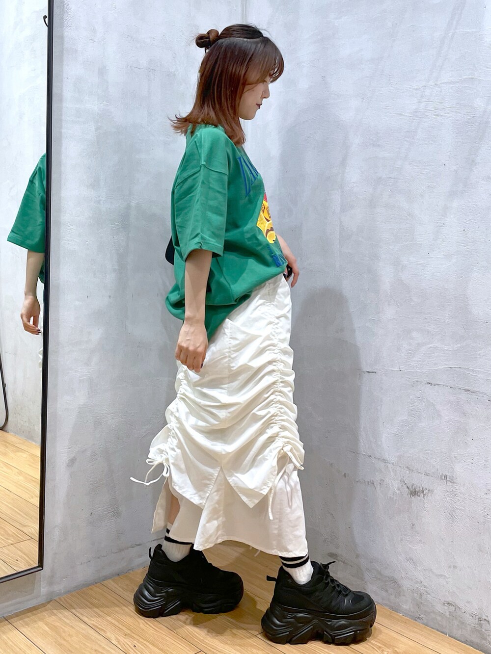 ブラック系のスニーカー、ホワイト系のスカート、ブラック系のハンドバッグを着用したレディースの春コーディネートの4枚目の写真