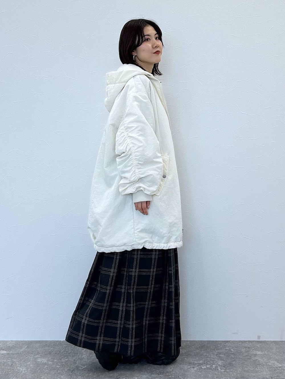 ブラック系のスニーカー、ホワイト系のブルゾン、ブルー系のニット/セーターを着用したレディースの秋コーディネートの4枚目の写真