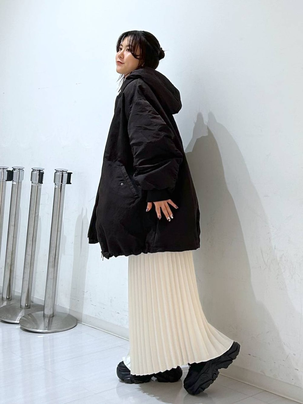 ブラウン系のブルゾン、ホワイト系のニット/セーター、ホワイト系のスカートを着用したレディースの冬コーディネートの5枚目の写真