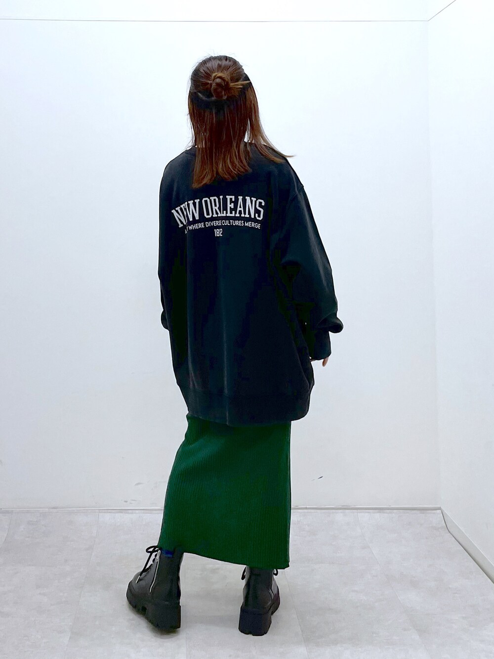 ブラック系のスウェット、グリーン系のワンピース、ブラック系のブーツを着用したレディースの冬コーディネートの4枚目の写真