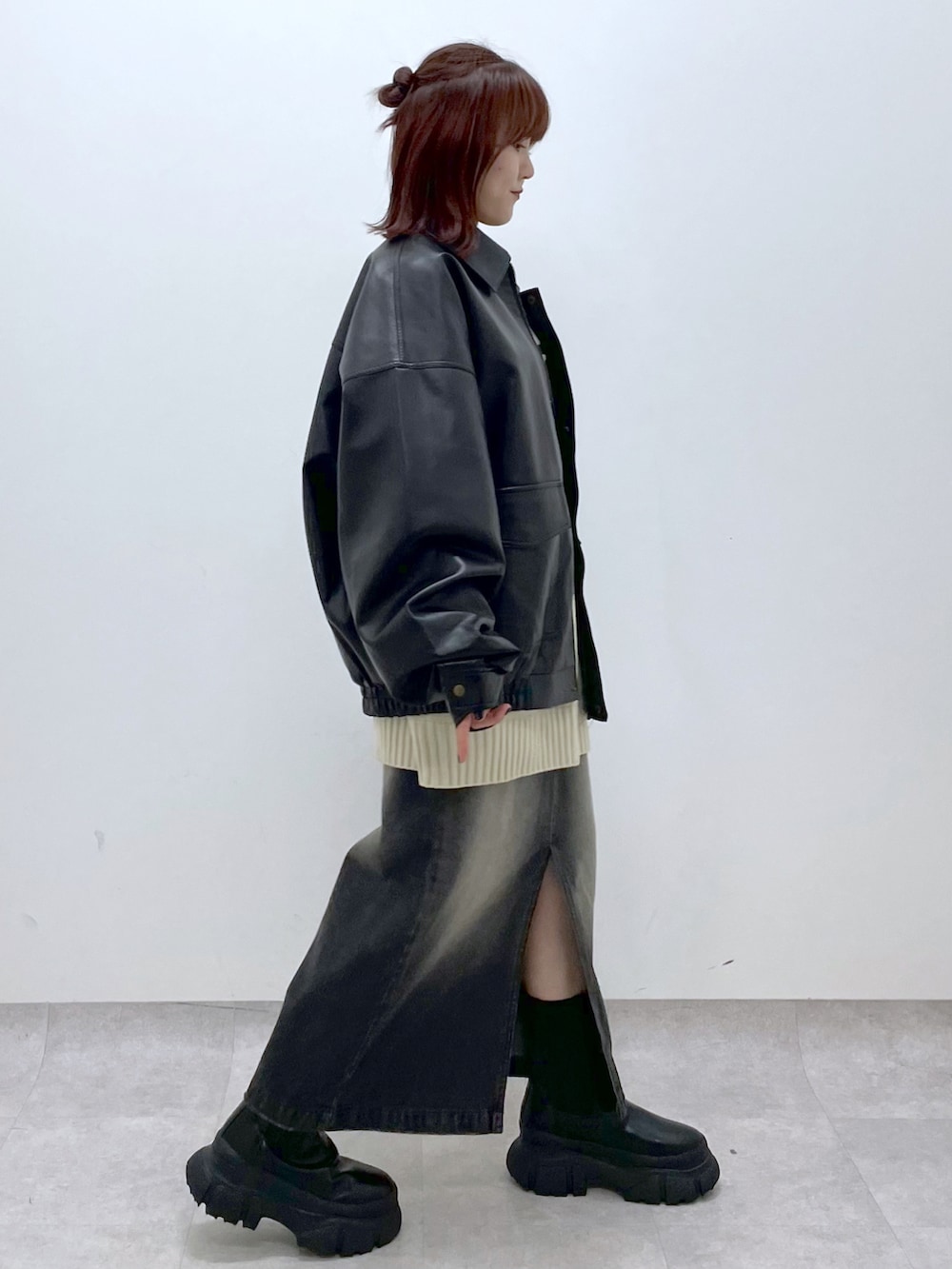 ブラック系のブーツ、ブラック系のスカート、ブラック系のブルゾンを着用したレディースの秋コーディネートの4枚目の写真