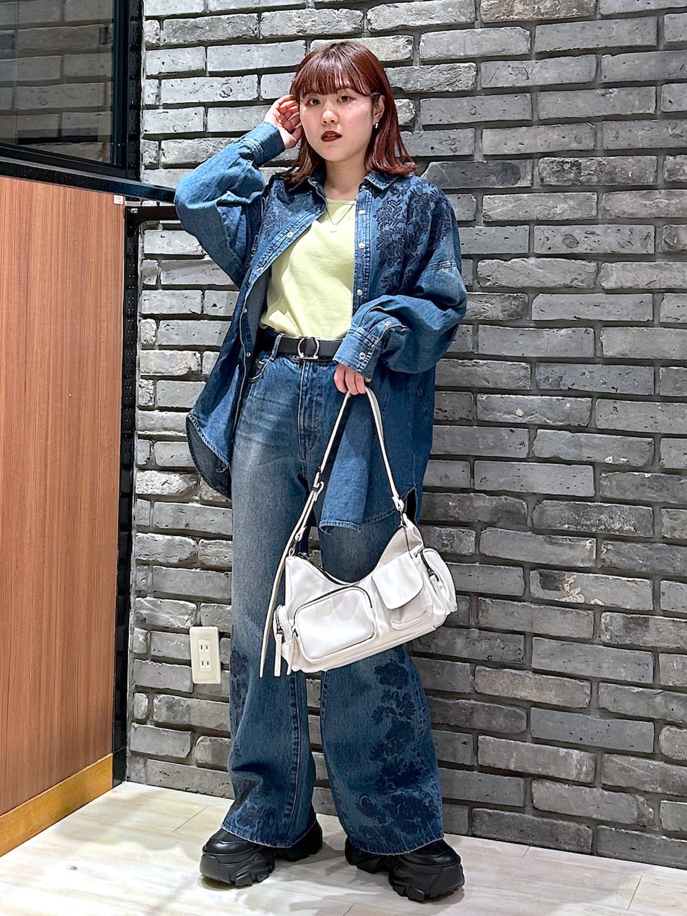 ブルー系のデニムパンツ、ブラック系のスニーカー、ブルー系のシャツ/ブラウスを着用したレディースの冬コーディネートの2枚目の写真