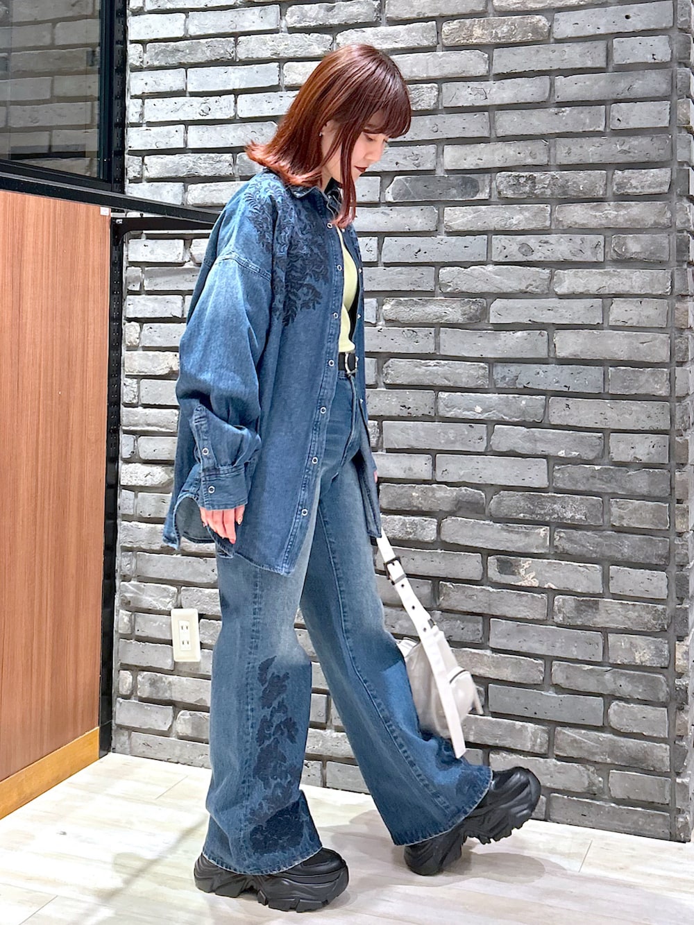 ブルー系のデニムパンツ、ブラック系のスニーカー、ブルー系のシャツ/ブラウスを着用したレディースの冬コーディネートの5枚目の写真