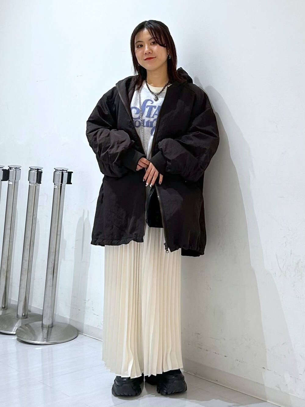 ブラウン系のブルゾン、ホワイト系のニット/セーター、ホワイト系のスカートを着用したレディースの冬コーディネートの3枚目の写真