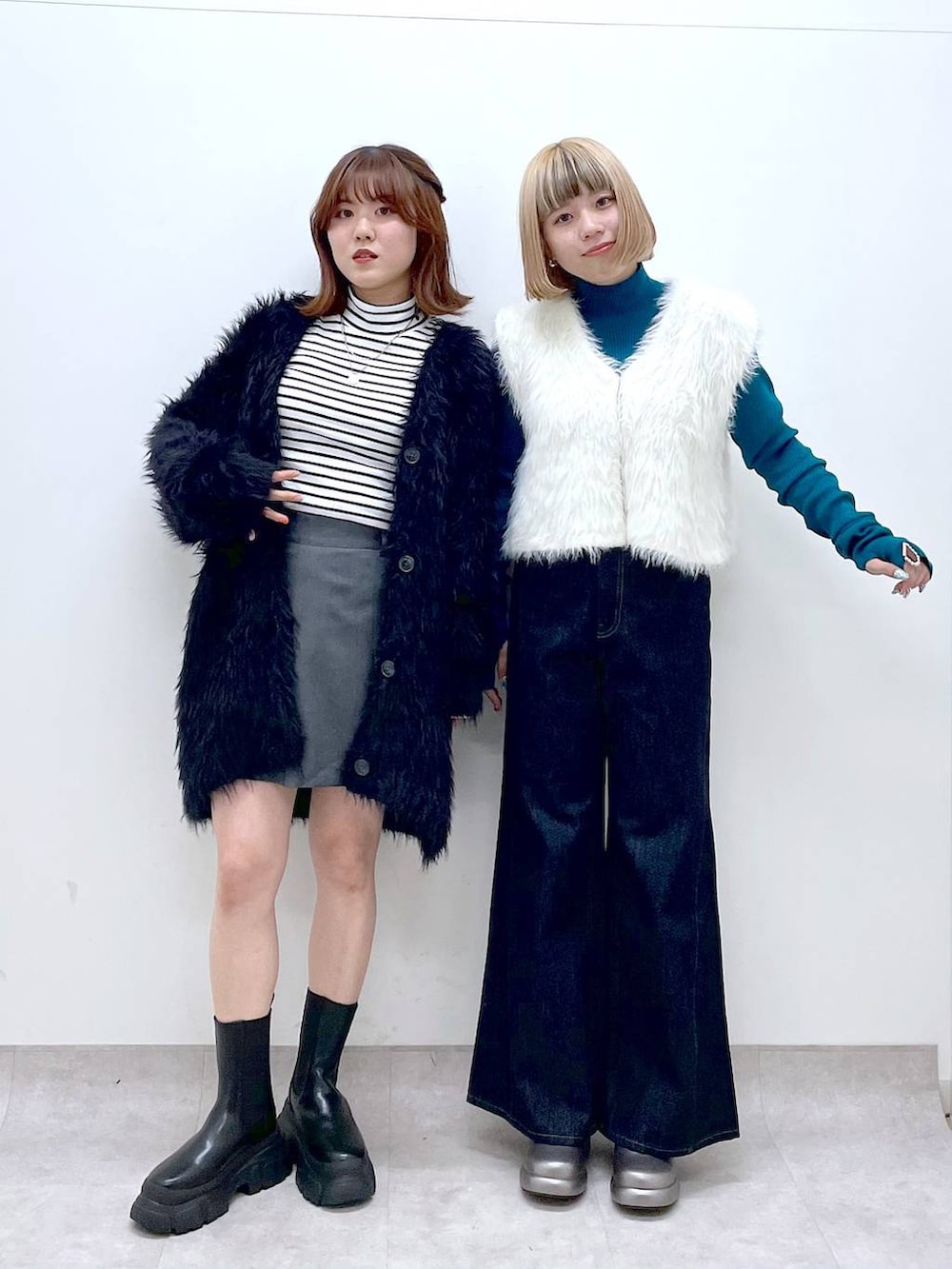 ブルー系のデニムパンツ、ブラック系のブーツ、ブラック系のカーディガン/ボレロを着用したレディースの秋コーディネートの3枚目の写真