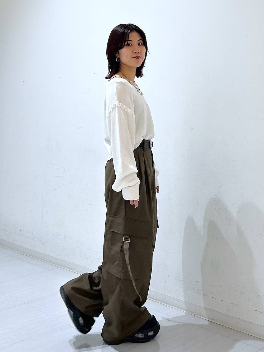 ホワイト系のTシャツ/カットソー、ブラウン系のスラックス、ブラック系のベルトを着用したレディースの秋コーディネートの5枚目の写真