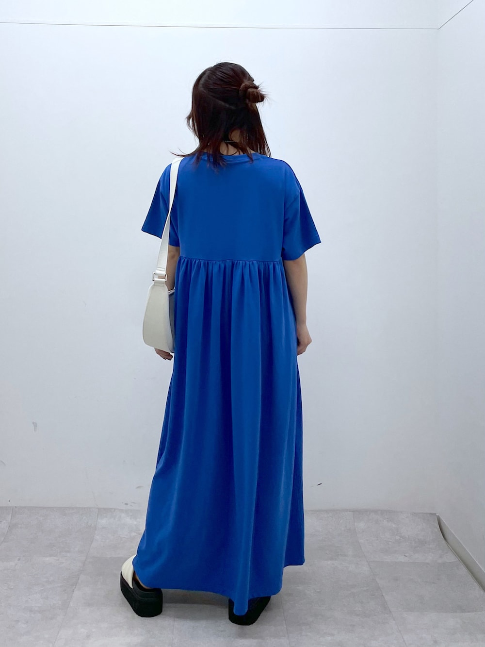 ブルー系のワンピース、ホワイト系のショルダーバッグ、ホワイト系のサンダルを着用したレディースの春コーディネートの4枚目の写真