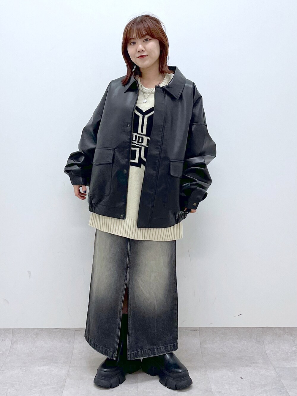 ブラック系のブーツ、ブラック系のスカート、ブラック系のブルゾンを着用したレディースの秋コーディネートの2枚目の写真