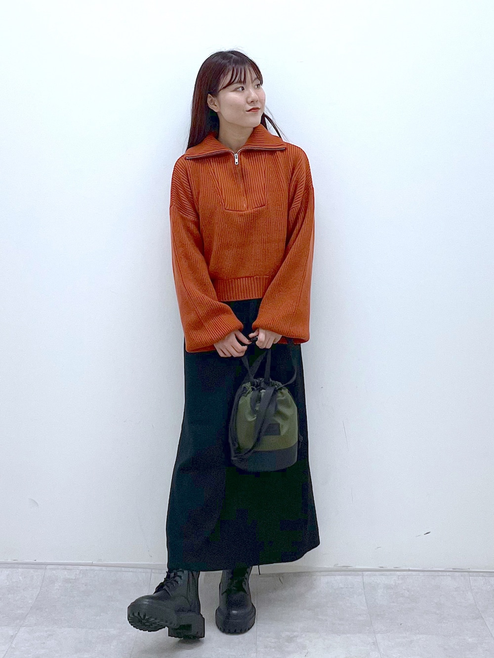 ブラック系のブーツ、ブラック系のワンピース、オレンジ系のニット/セーターを着用したレディースの秋コーディネートの4枚目の写真