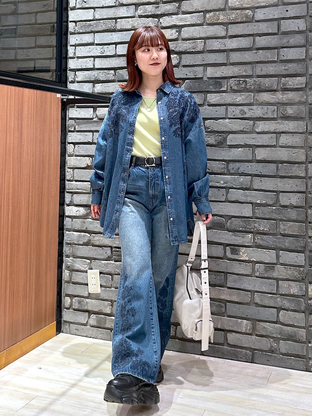 ブルー系のデニムパンツ、ブラック系のスニーカー、ブルー系のシャツ/ブラウスを着用したレディースの冬コーディネートの3枚目の写真