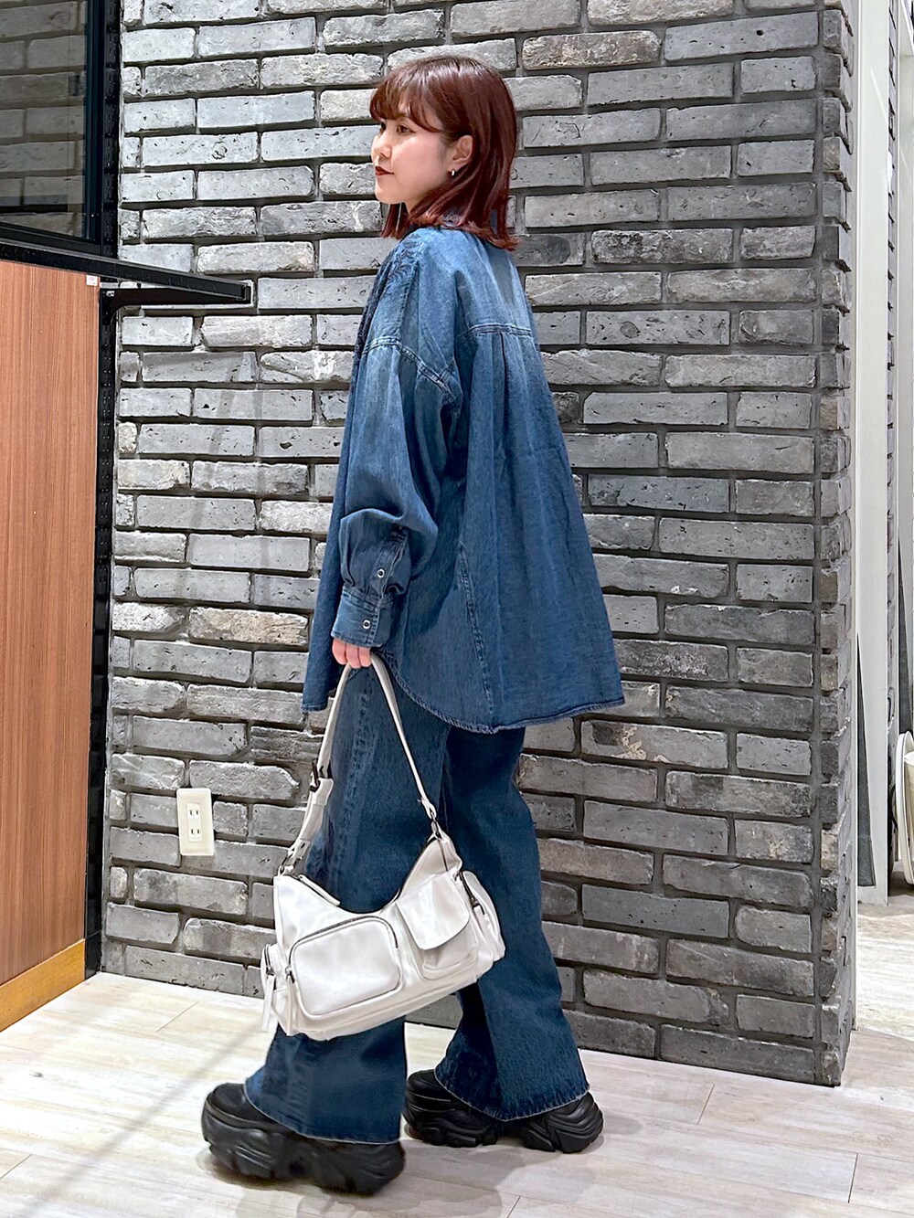 ブルー系のデニムパンツ、ブラック系のスニーカー、ブルー系のシャツ/ブラウスを着用したレディースの冬コーディネートの4枚目の写真